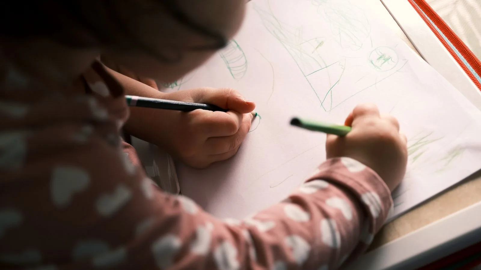 Photographie : un enfant de six ans occupé à dessiner